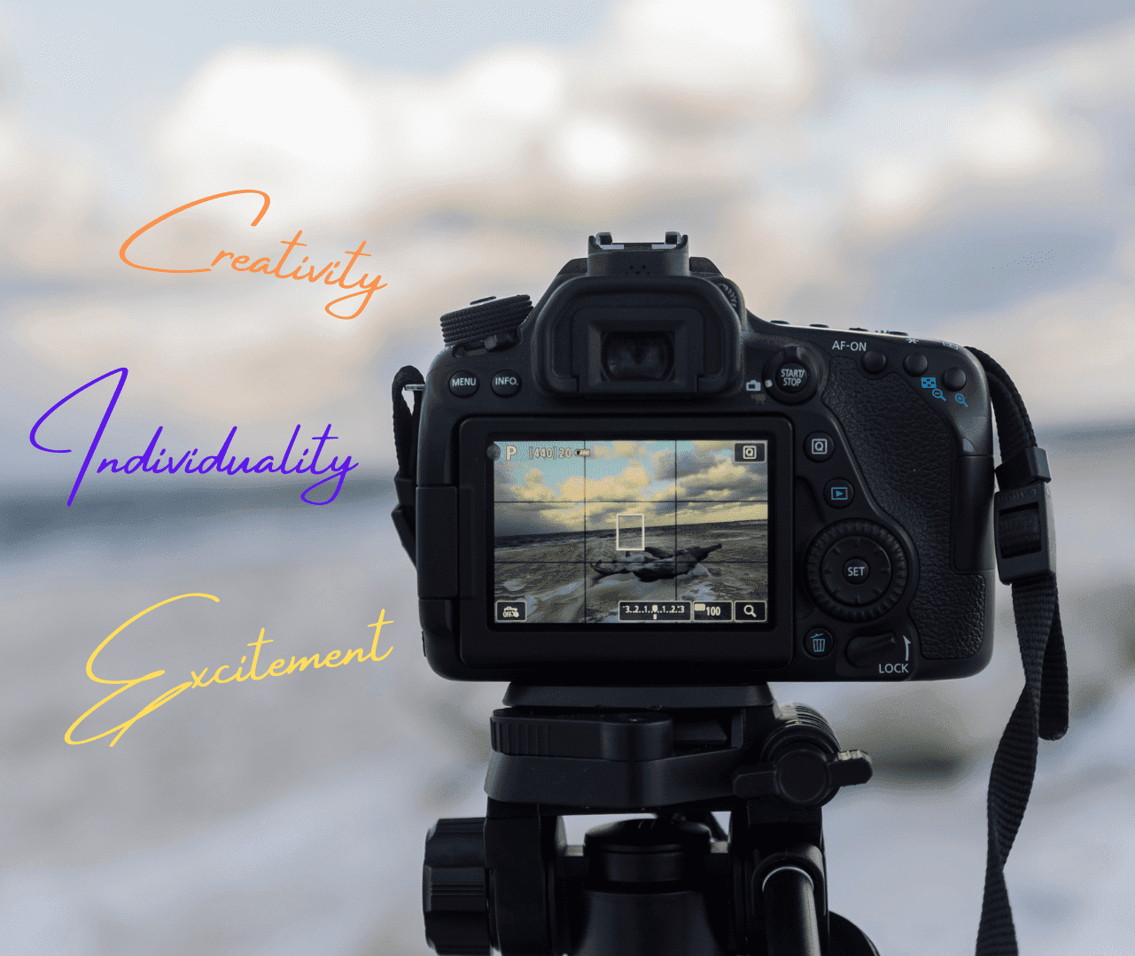 Fotokamera und Schrift vor Strand mit Wolken